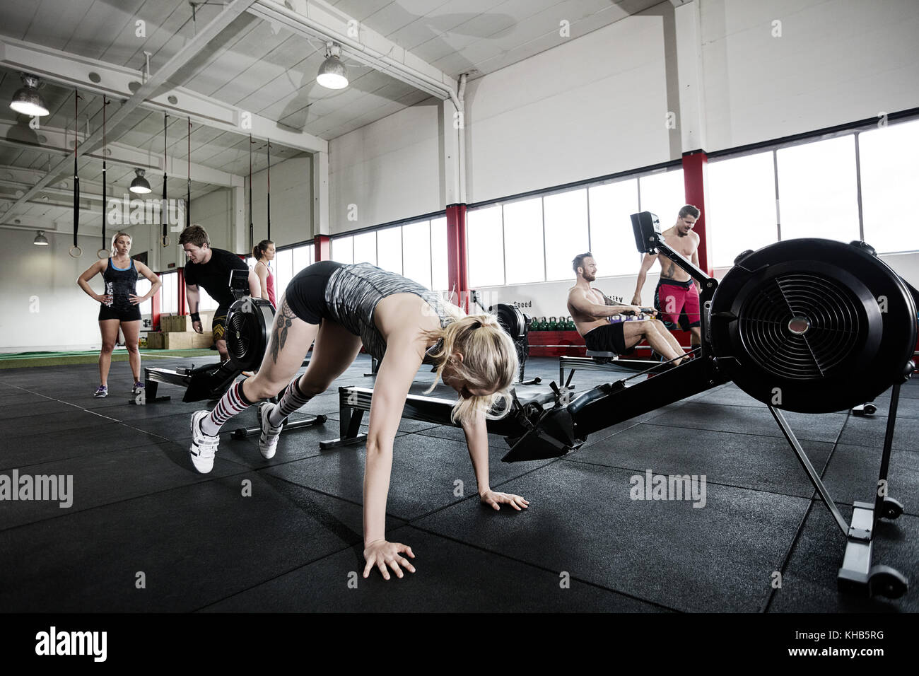 Determined young woman exercising by rowing machine in gym Stock Photo ...