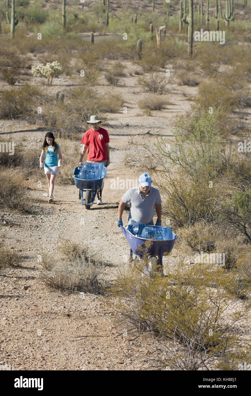 Ajo, Arizona, USA. 16th Oct, 2010. Humane Borders volunteers Lawn Griffiths, (front), Tempe, Ariz., John Asher, Phoenix, and his daughter, Caetlin, 12, restock water at a water station in Organ Pipe National Monument in the Sonoran Desert south of Ajo Arizona. Humane Borders maintains more than 100 water stations along the US/Mexico border in an effort to stem the death toll of migrants who enter the U.S., using the most dangerous and inhospitable routes through the desert. Although the number of people of illegally crossing into the U.S. through Arizona is down, the death toll set a recor Stock Photo