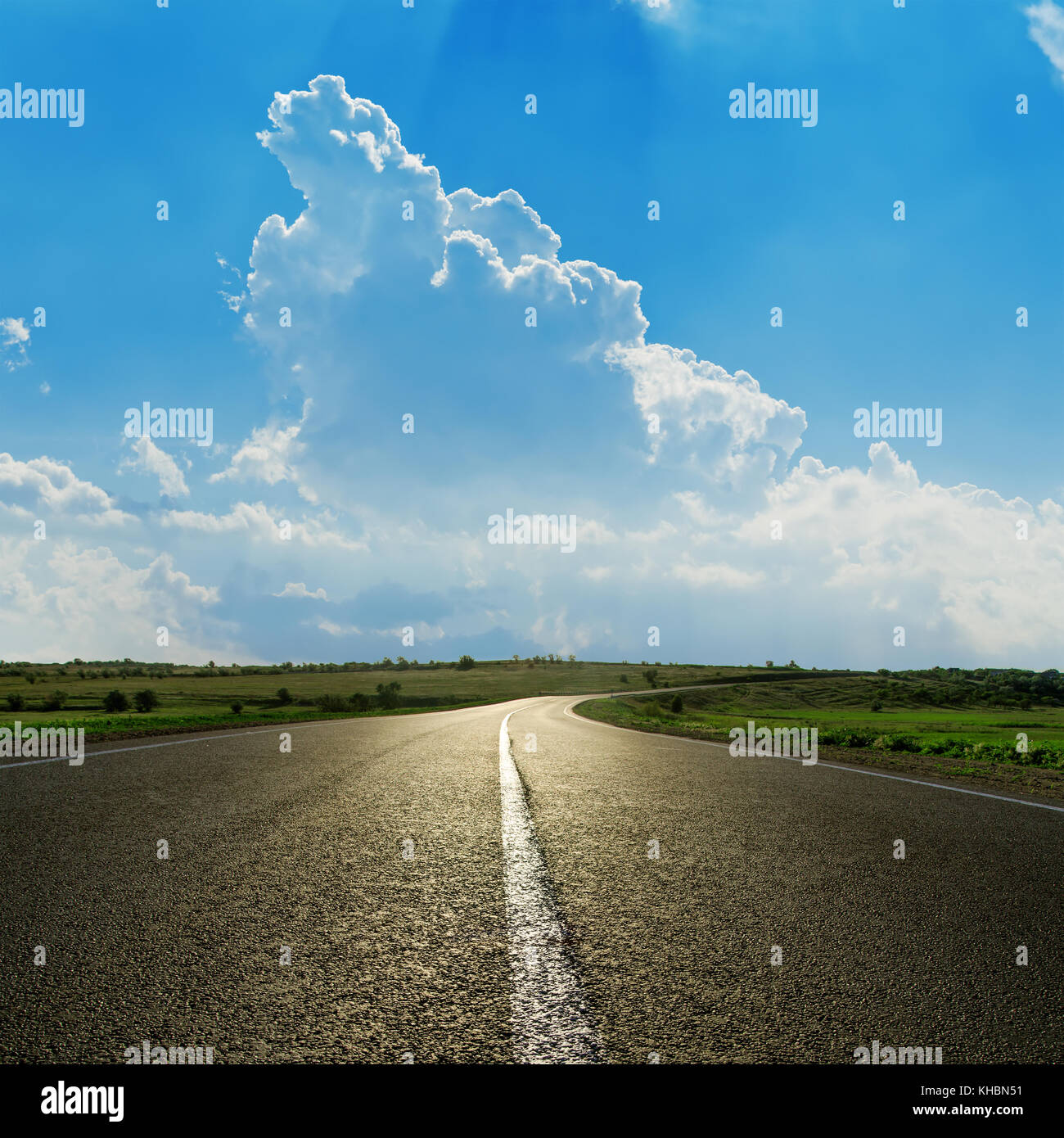 asphalt road closeup under cloudy blue sky Stock Photo - Alamy