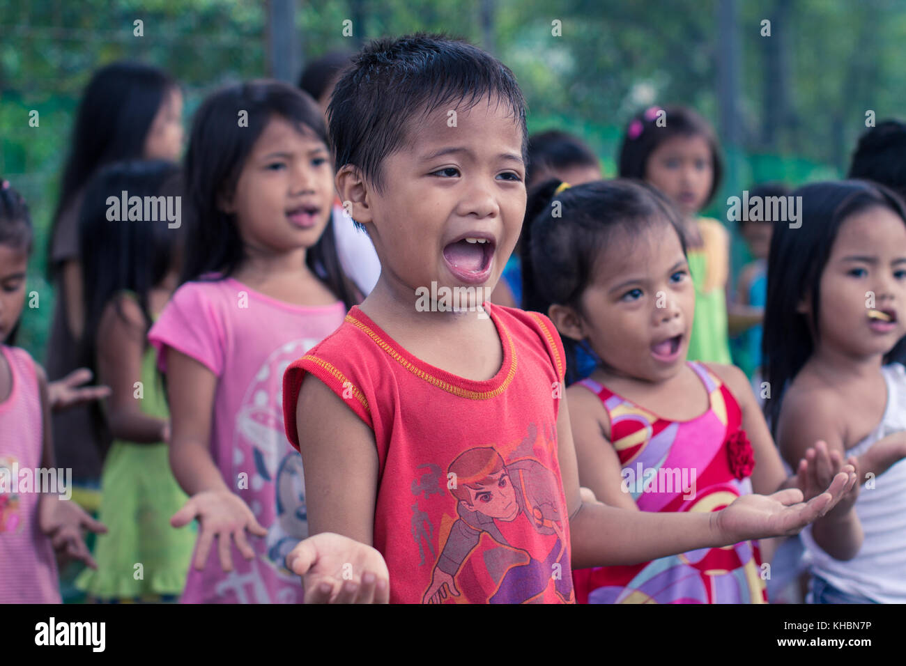 Children worships at a charity program in the slum. Poor children finding hope in their faith. Stock Photo