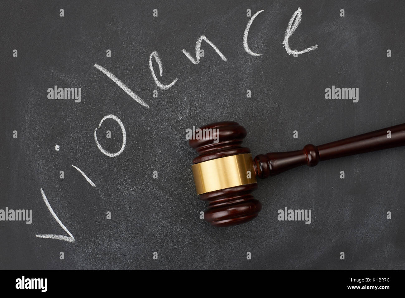 Judge gavel on blackboard background writing the word 'violence'. Stock Photo