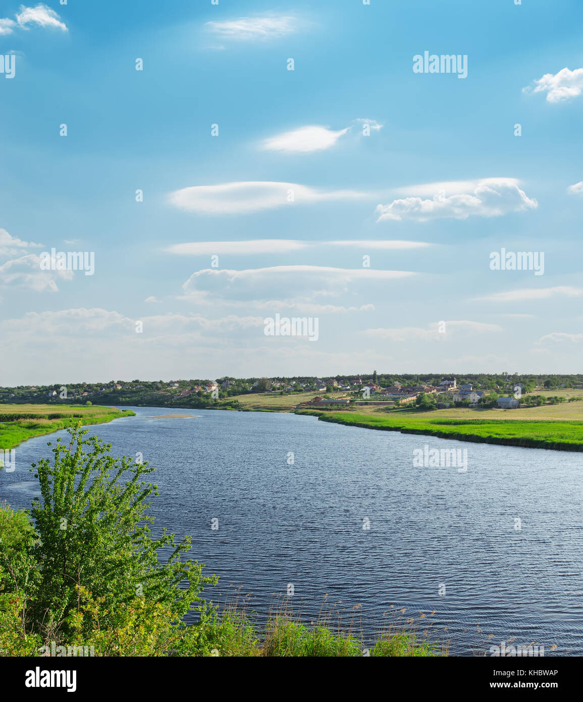 river with green riverside and light cloudy sky Stock Photo - Alamy