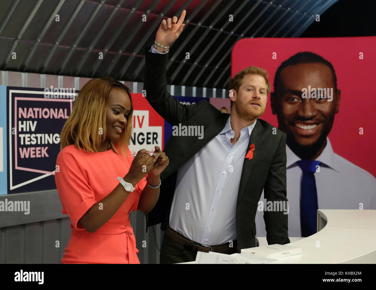 Yvette Twagiramariya, one of the faces of the 'It Starts With Me' campaign, demonstrates an HIV self-testing kit to Prince Harry at the opening of the Terrence Higgins Trust (THT) HIV testing pop-up shop in Hackney, London. Stock Photo