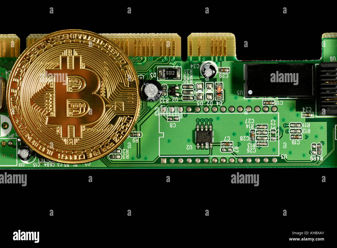 Symbol image digital currency, gold physical coin Bitcoin on printed circuit board Stock Photo