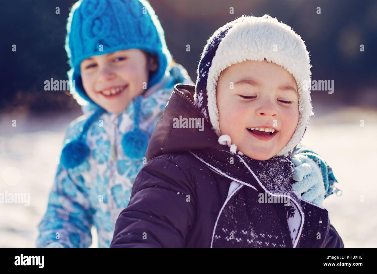 Siblings play in snow Stock Photo - Alamy