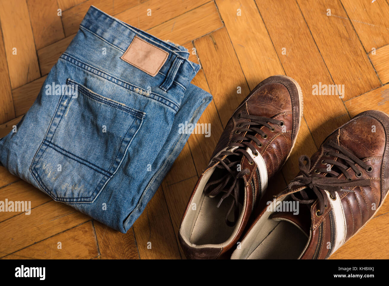 Brown shoes and blue jeans lie by on the floor Stock Photo - Alamy