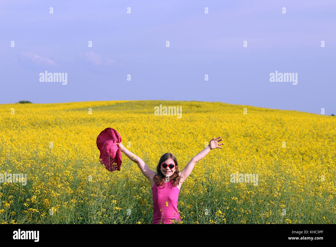 happy little girl with hands up on field summer season Stock Photo - Alamy