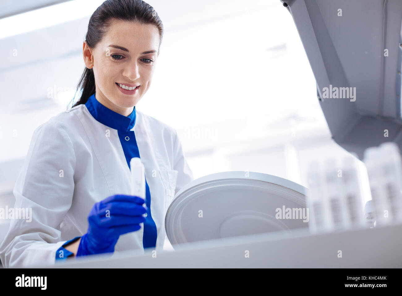 Happy young scientist scrutinizing apparatus  Stock Photo