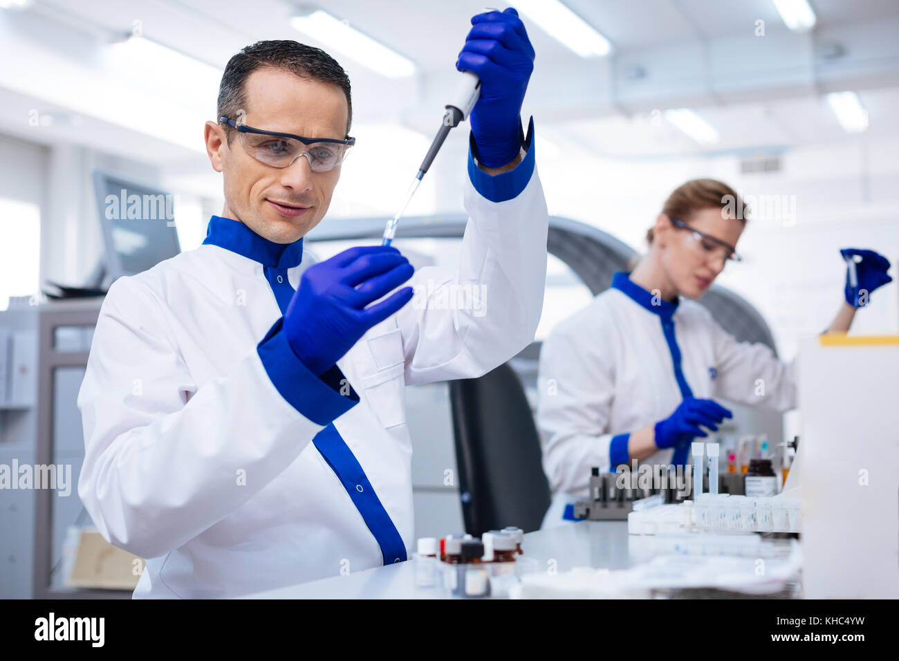 Lab Helpers Enthusiastic lab assistant working with a pipette Stock Photo - Alamy