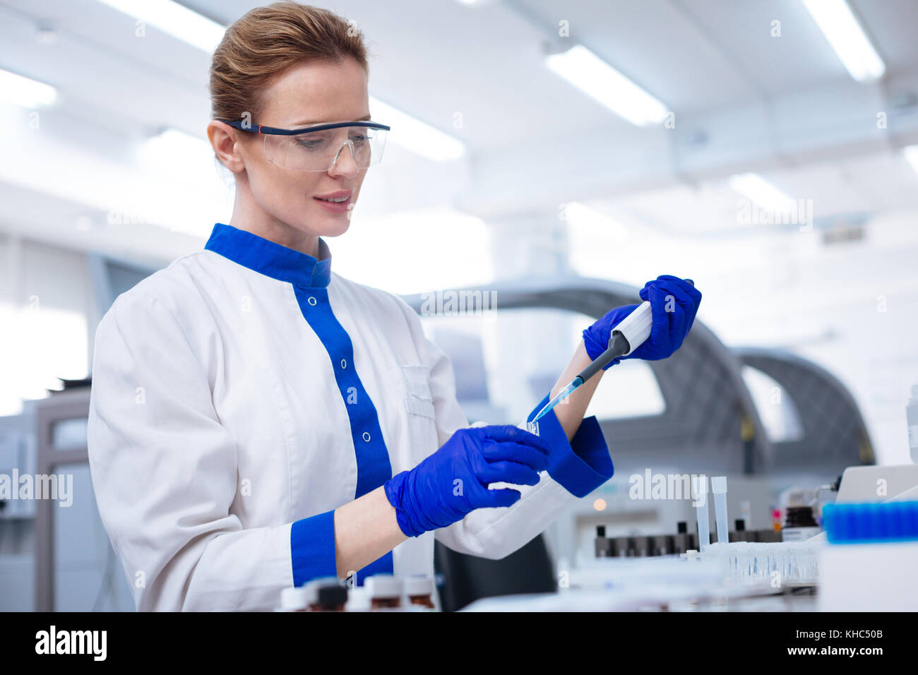Calm concentrated scientist adding chemical Stock Photo