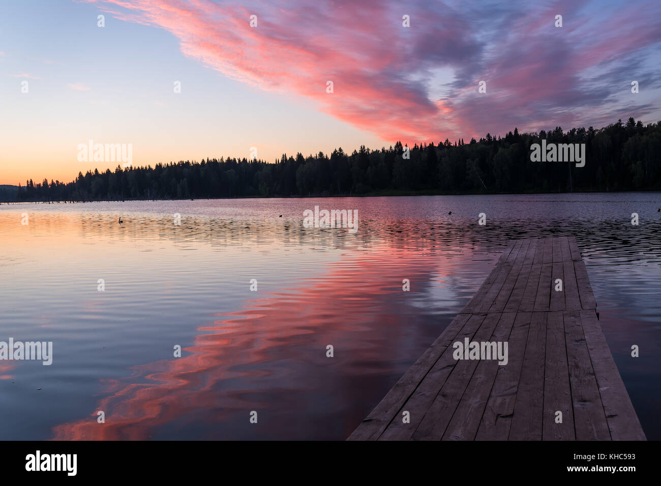 The picturesque pink and orange sunrise over a lake with beautiful ...