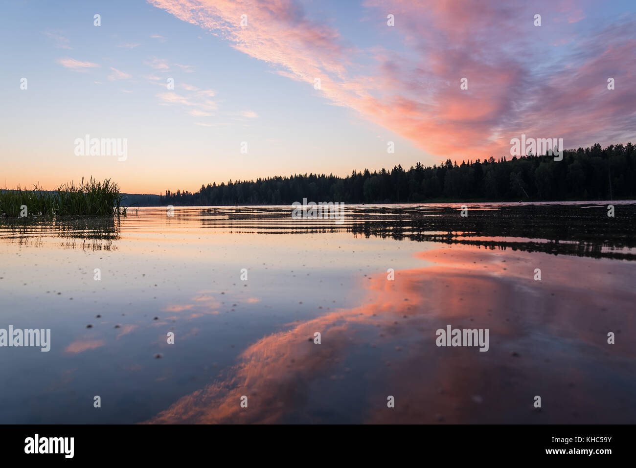 The picturesque pink and orange sunrise over a lake with beautiful ...