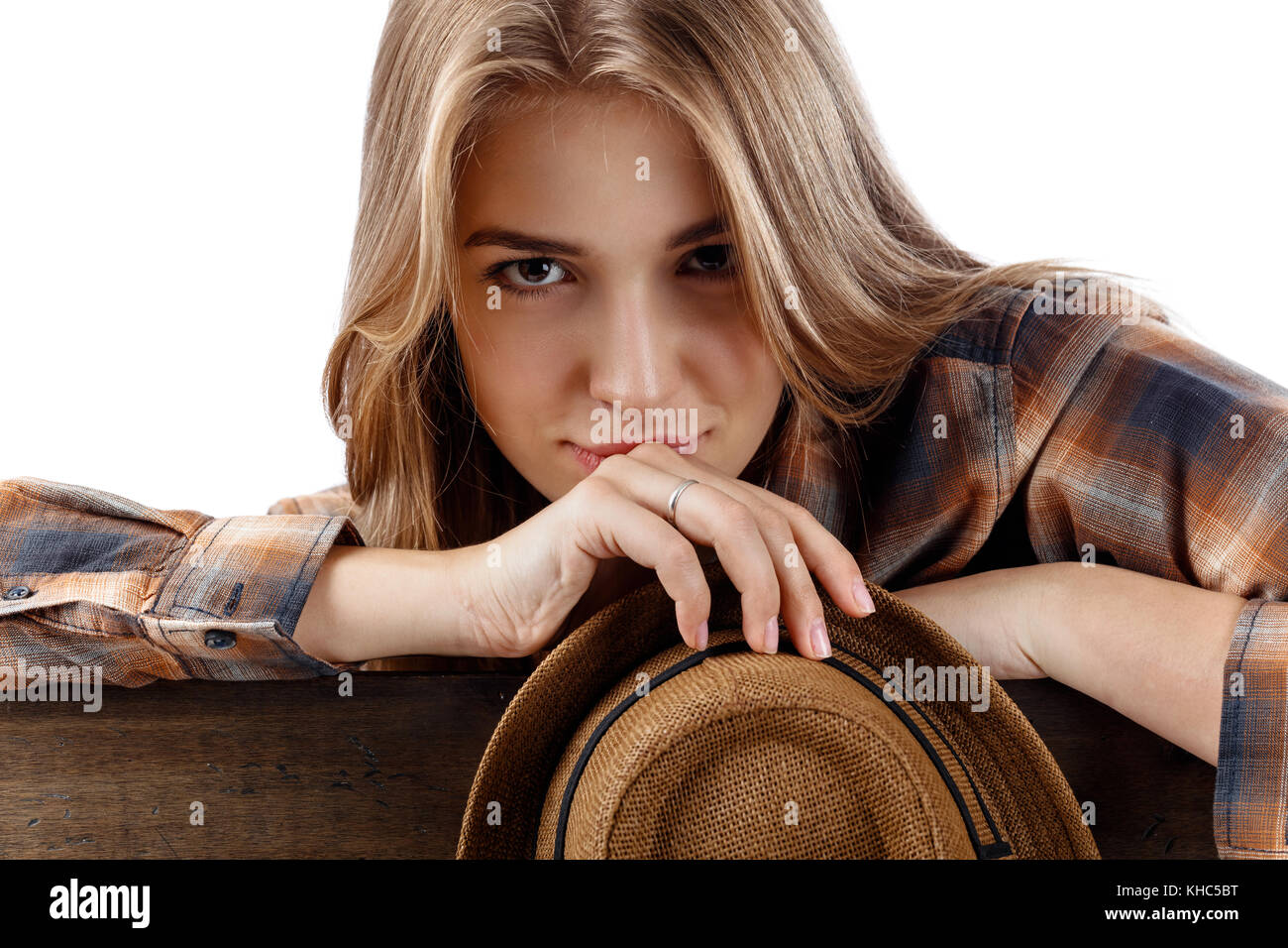 Young pretty blonde woman in brown  plaid shirt with hat . Beautiful girl isolated on white background. Stock Photo