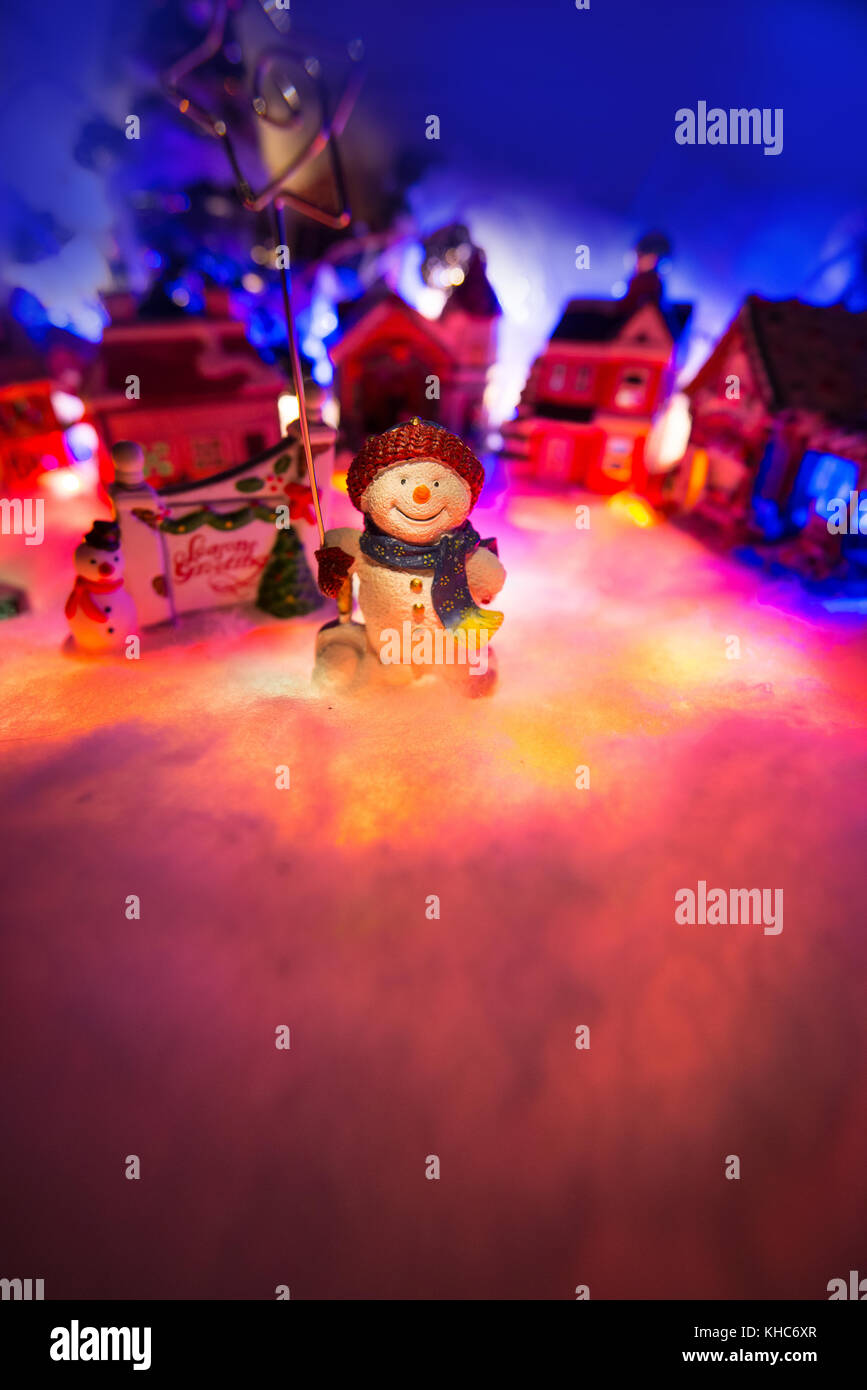 g star of Bethlehem stands in front of a snowy Christmas village. Miniature figurine Stock Photo