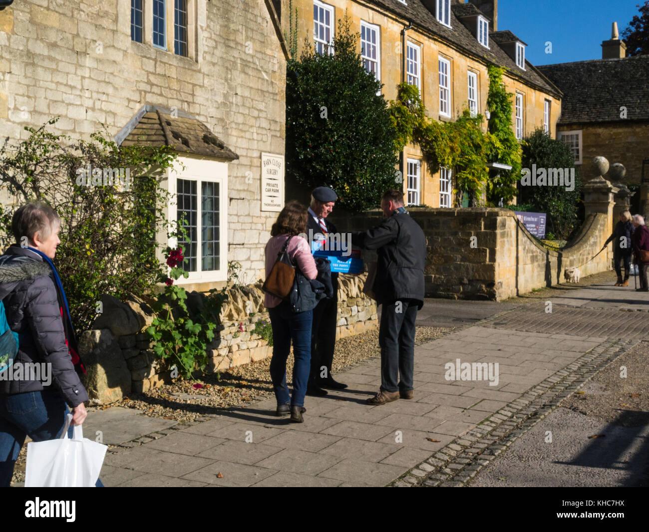 People buying a poppy from a British Legion poppy seller Broadway Worcestershire England UK Stock Photo