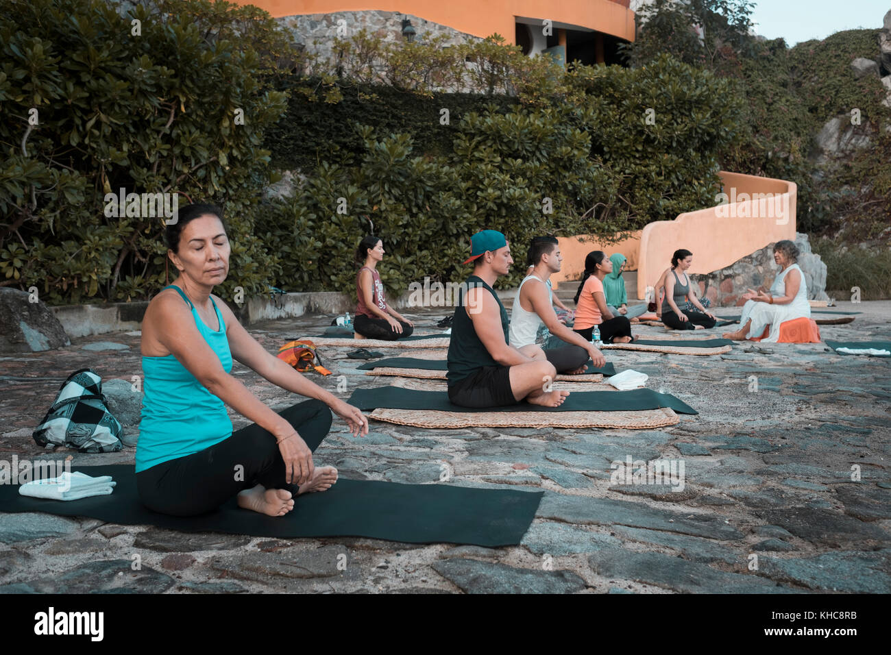 Yoga retreat, group of people sitting and meditating on mats, Puerto Vallarta - Mismaloya, Mexico Stock Photo