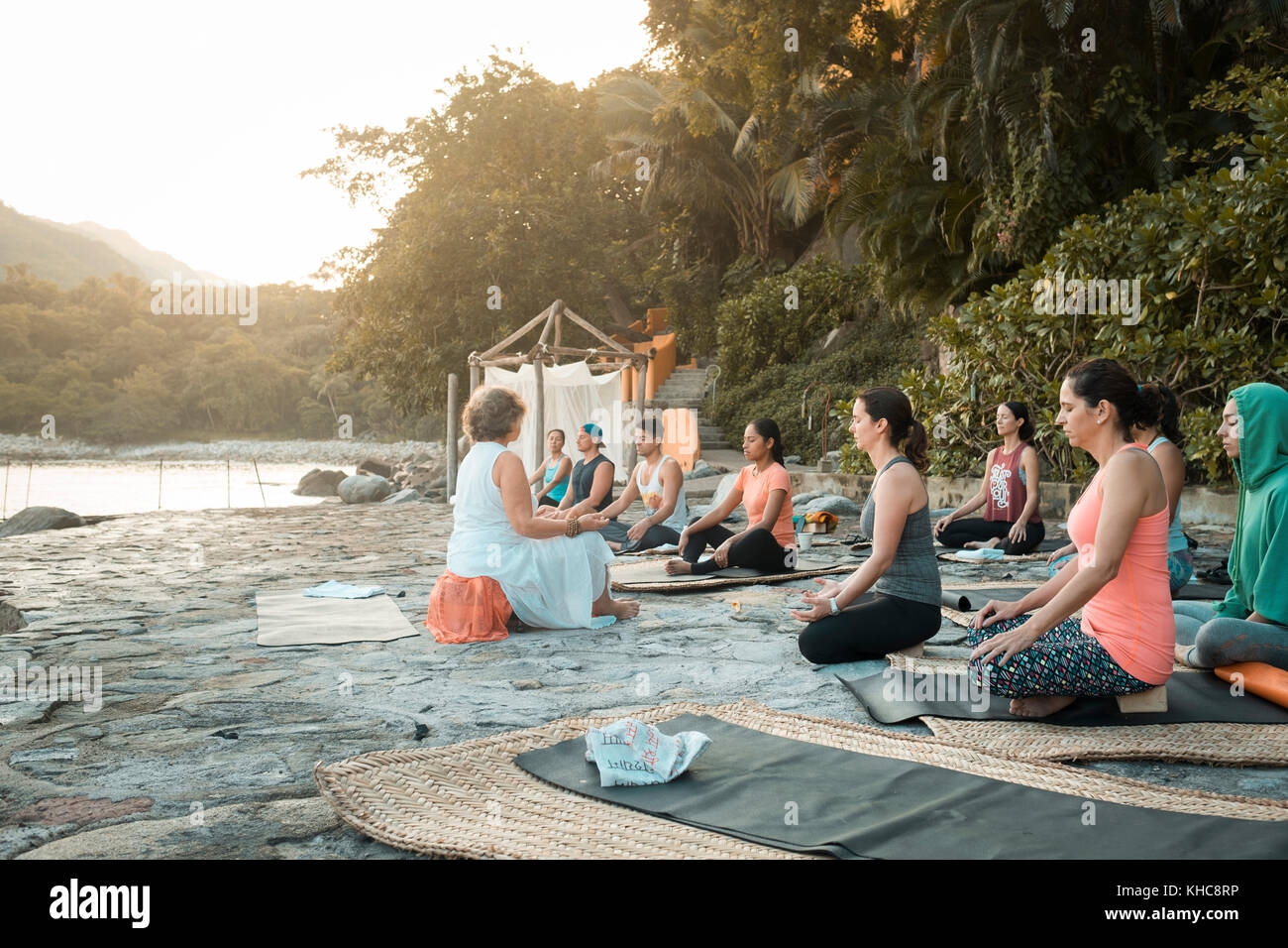 Yoga retreat Puerto Vallarta - Mismaloya, Mexico - multiple people sitting on yoga mats meditating with eyes closed. Stock Photo