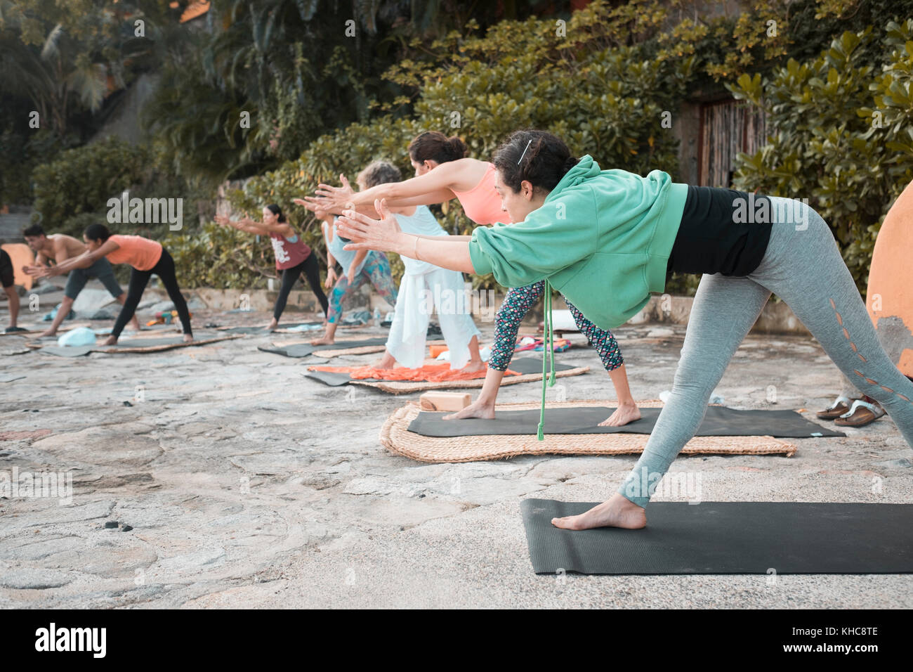 Yoga group - multiple people exercising outdoors. Stock Photo