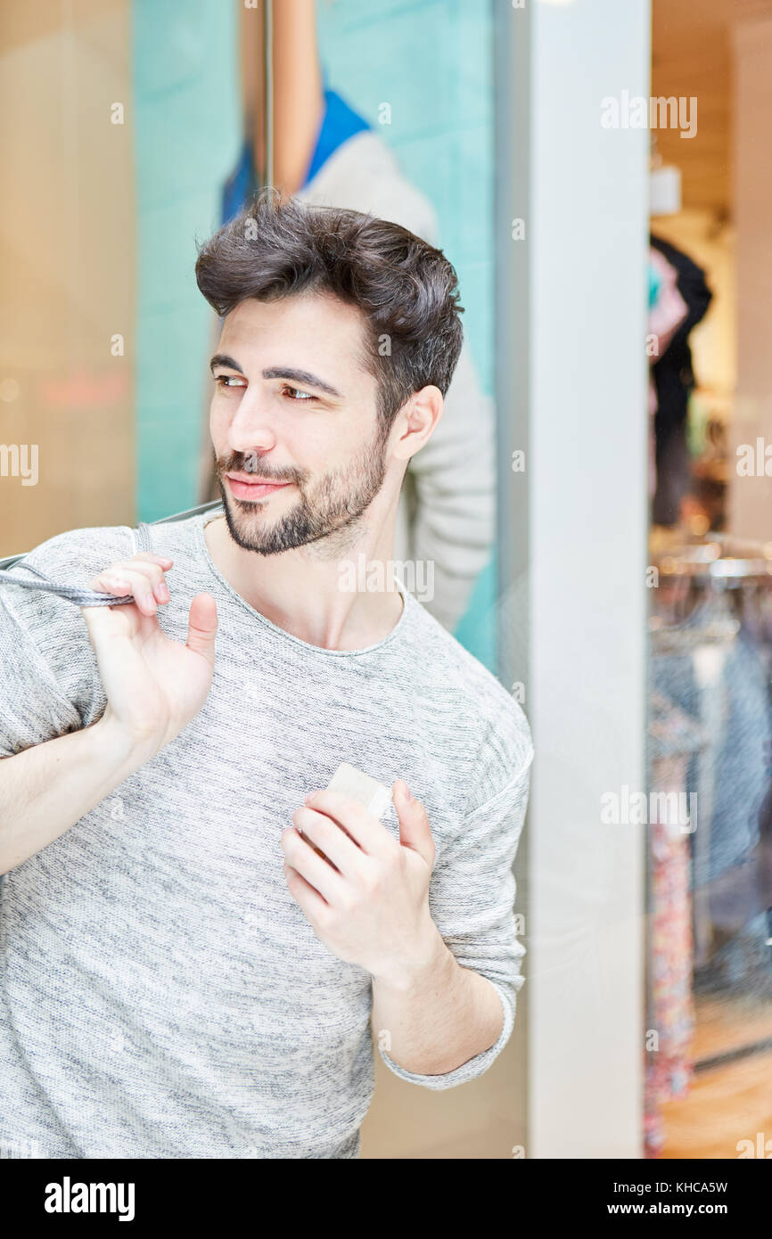 Young man as customer and consumer in shopping mall while shopping Stock Photo