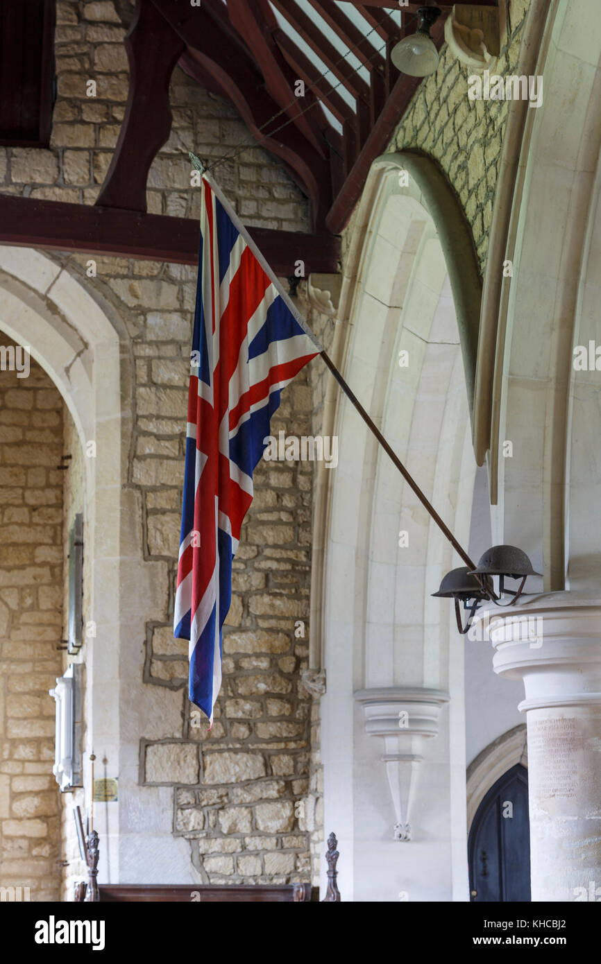 Interior of St Swithuns Church, Brookthorpe, Gloucestershire, an historic church, showing a Union Flag and 'Tommies' helmets' for remembrance services Stock Photo