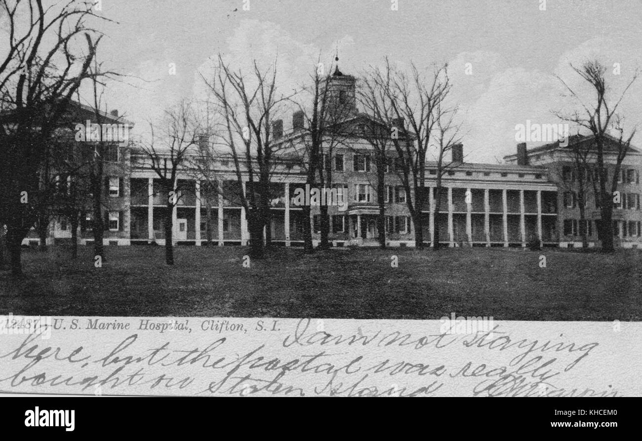 A postcard from a photograph of the exterior of a US Marine Hospital, construction of the medical campus began in 1831 and was built to provide treatment to sailors in the Merchant Marines, Coast Guard, and other federal employees, the image was captured from a distance across a lawn containing scattered trees, the building is a sprawling grey stonework multi-story structure, Clifton, Staten Island, New York, 1900. From the New York Public Library. Stock Photo