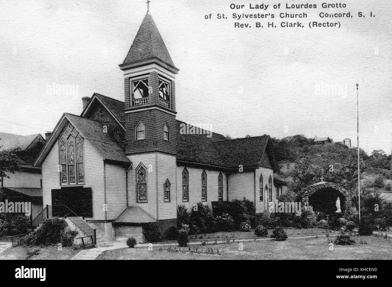 A postcard from an exterior photograph of St Sylvester's Church, included in the photograph is the outdoor grotta constructed in honor of Our Lady Lourdes, the grotto was dug into the surrounding hillside behind the church, Concord, Staten Island, New York, 1900. From the New York Public Library. Stock Photo