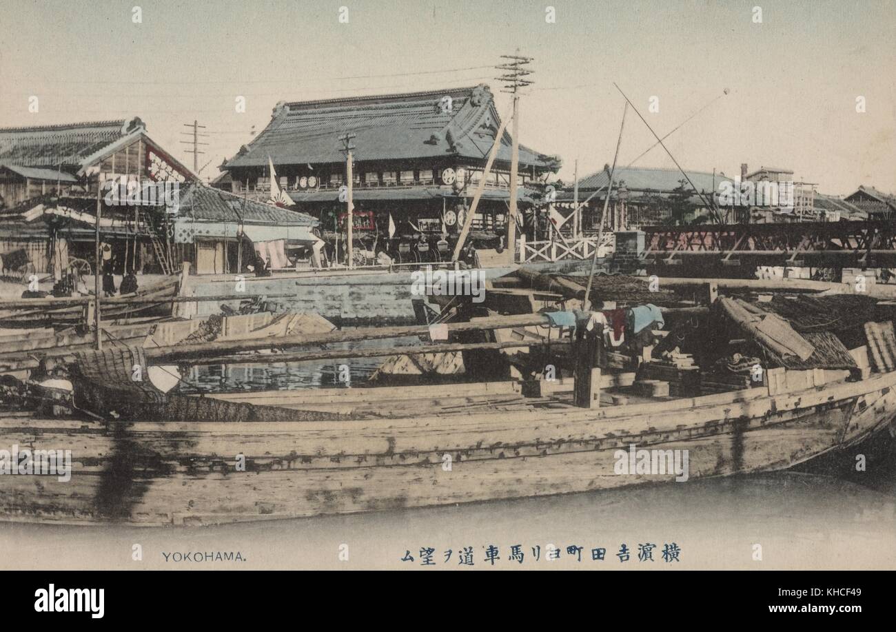 Postcard picture of an old Japanese Fishing Village showing a few boats docked on a wharf with several Japanese old buildings in the background, Yokohama, Japan, 1904. From the New York Public Library. Stock Photo