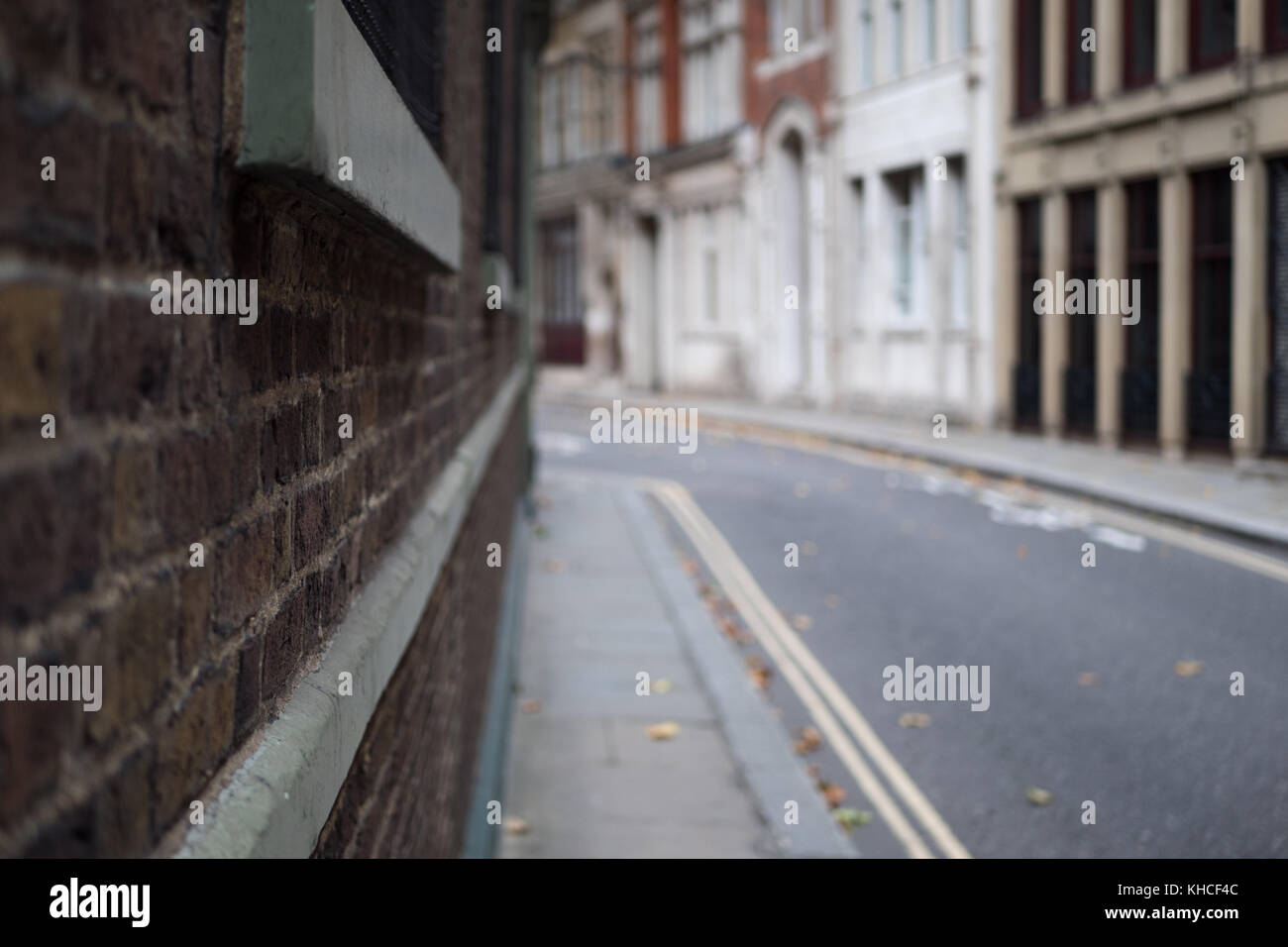 Looking onto an empty back street in London. Camera is pushed against the wall for a subjective view. Stock Photo