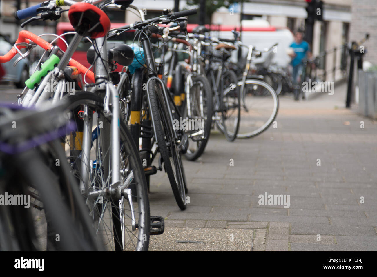 A long row of bikes chained to a railing on Westgate Street in Hackney Stock Photo