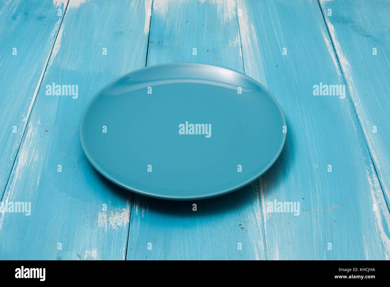 Blue Round plate on blue wooden table with perspective side view Stock Photo