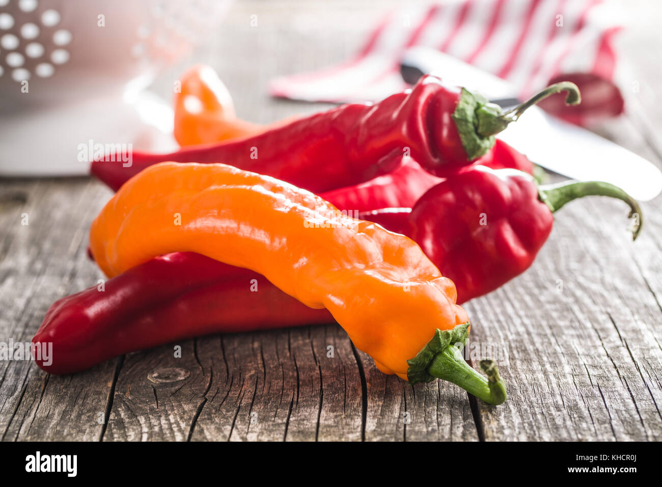 Orange and red peppers on old wooden table Stock Photo - Alamy