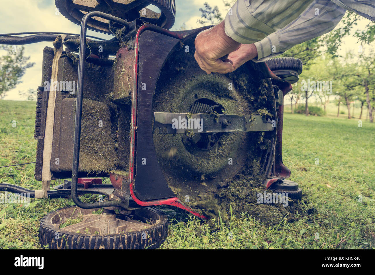 Man cleaning lawn mower blade Stock Photo Alamy