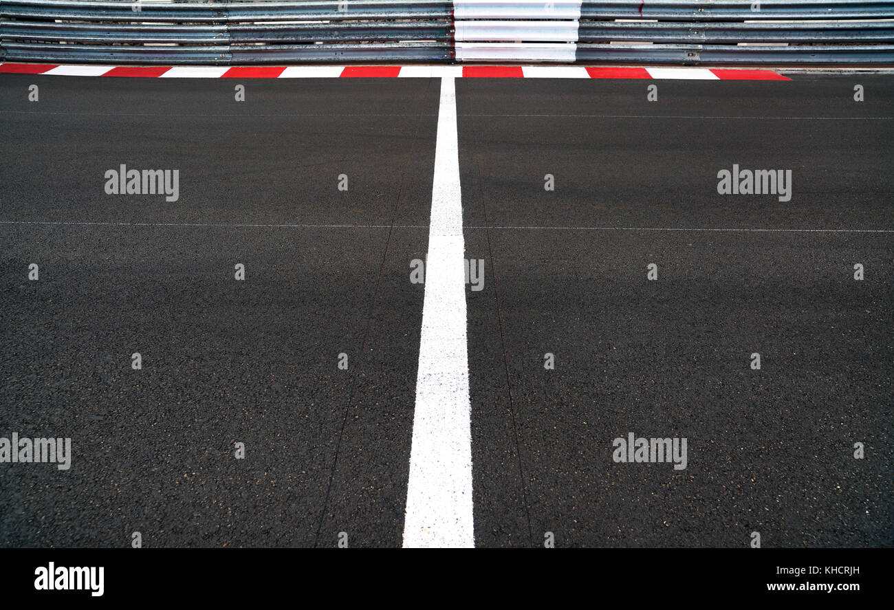 Start and Finish motor race line asphalt on Grand Prix street circuit. Red and white curb, guard rail or guardrail on background Stock Photo