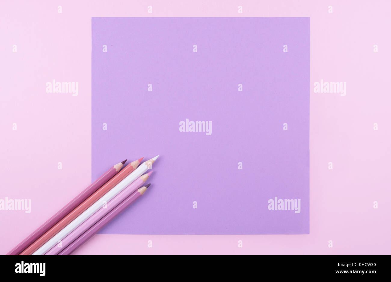 Colored pencils on pink and lila background. Flat lay style with space for your text. Stock Photo