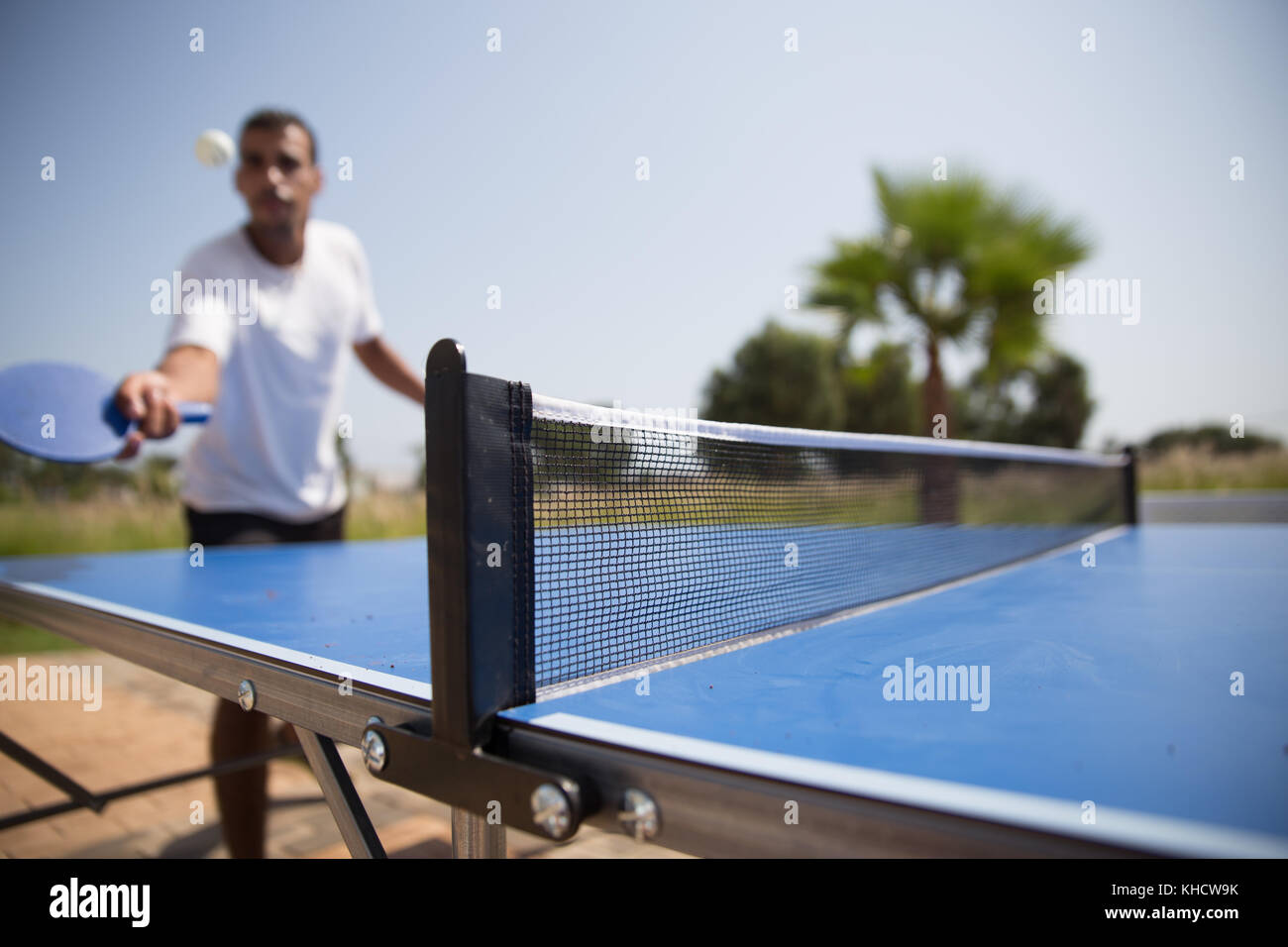 Unidentified man playing ping pong outdoors Stock Photo