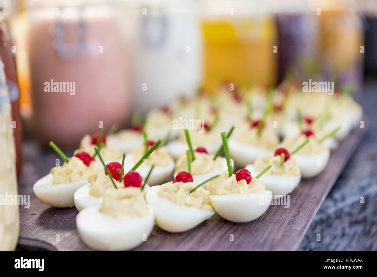 Eggs with mayonnaise inside, jars of sauce in the background Stock Photo