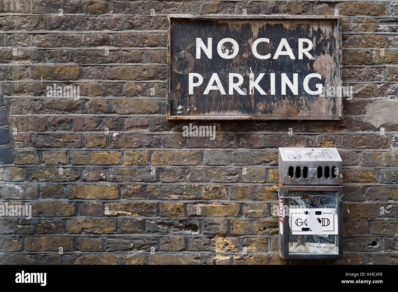 Brick masonry wall with a vintage 'No Car Parking' sign. Landscape format. Vintage look. Stock Photo