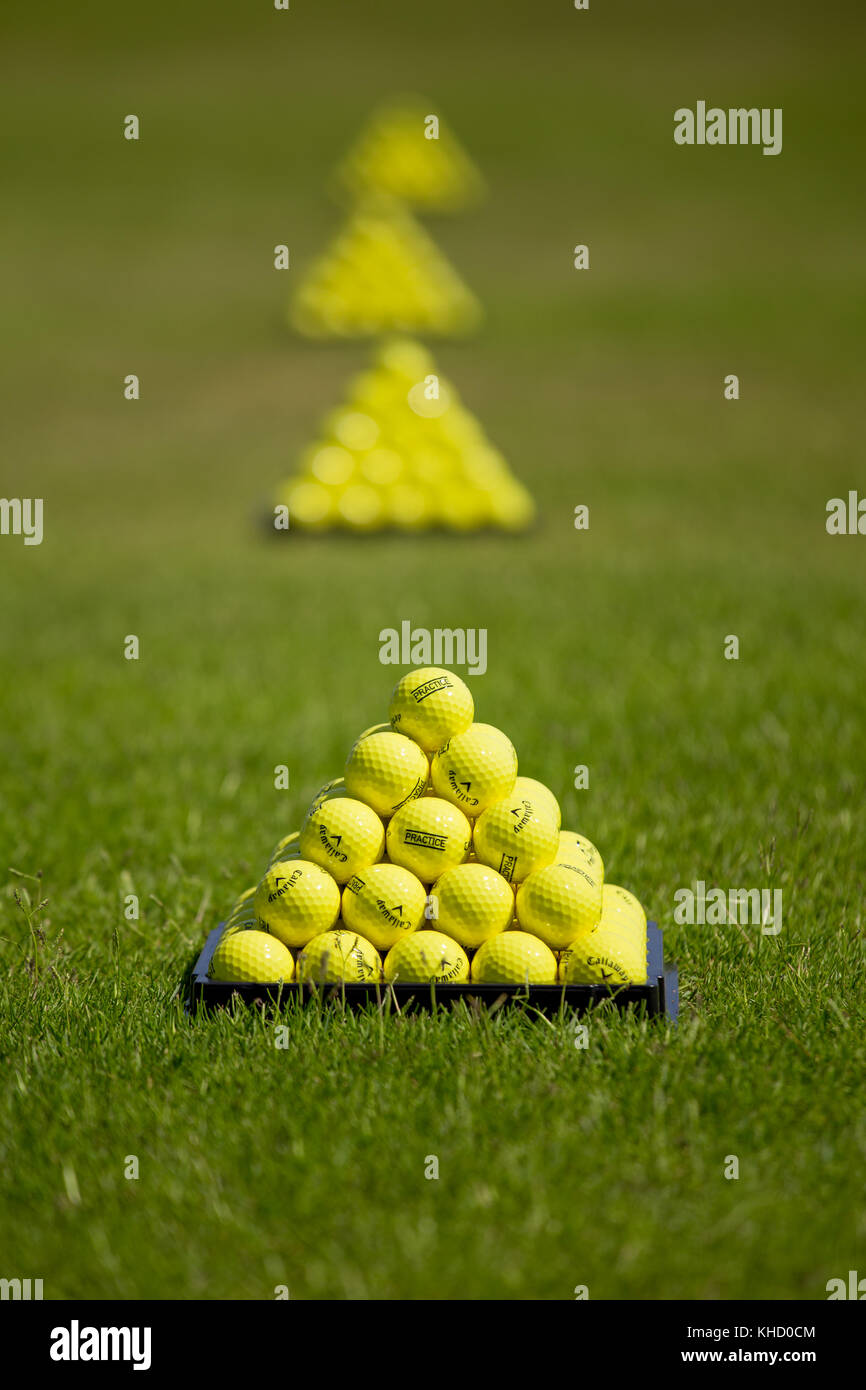 Pile of Callaway yellow golf practice balls in form of pyramids on tee Stock Photo