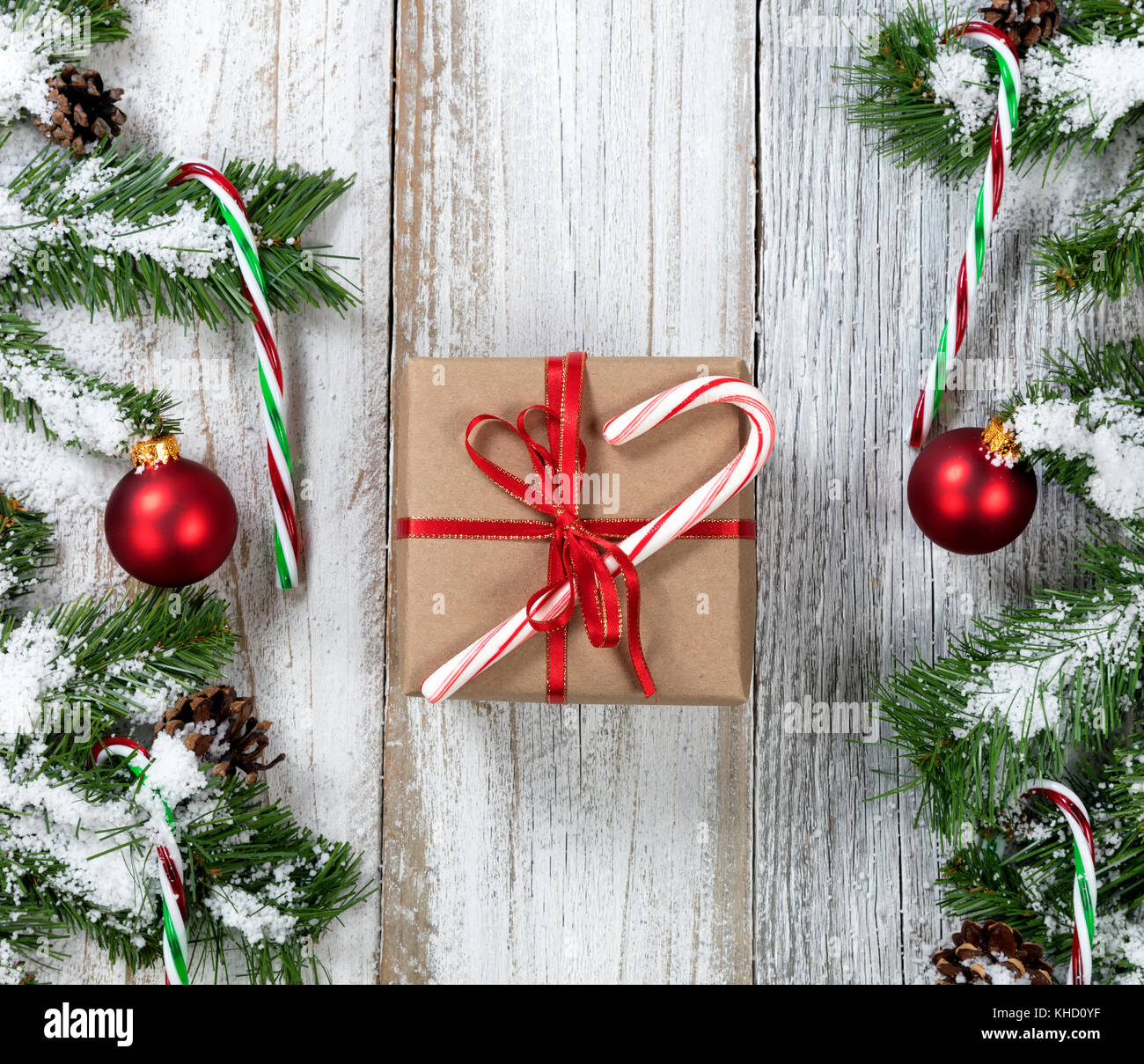 Christmas Gift with candy cane surrounded by snowy tree branches, candy ...