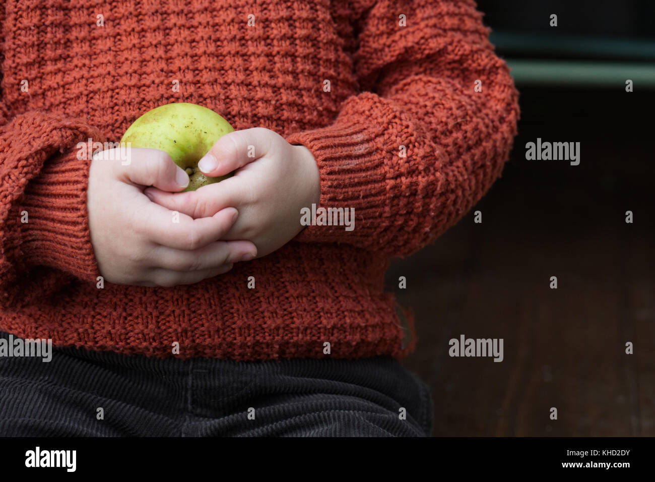 Boy holding green apple, mid section close up Stock Photo