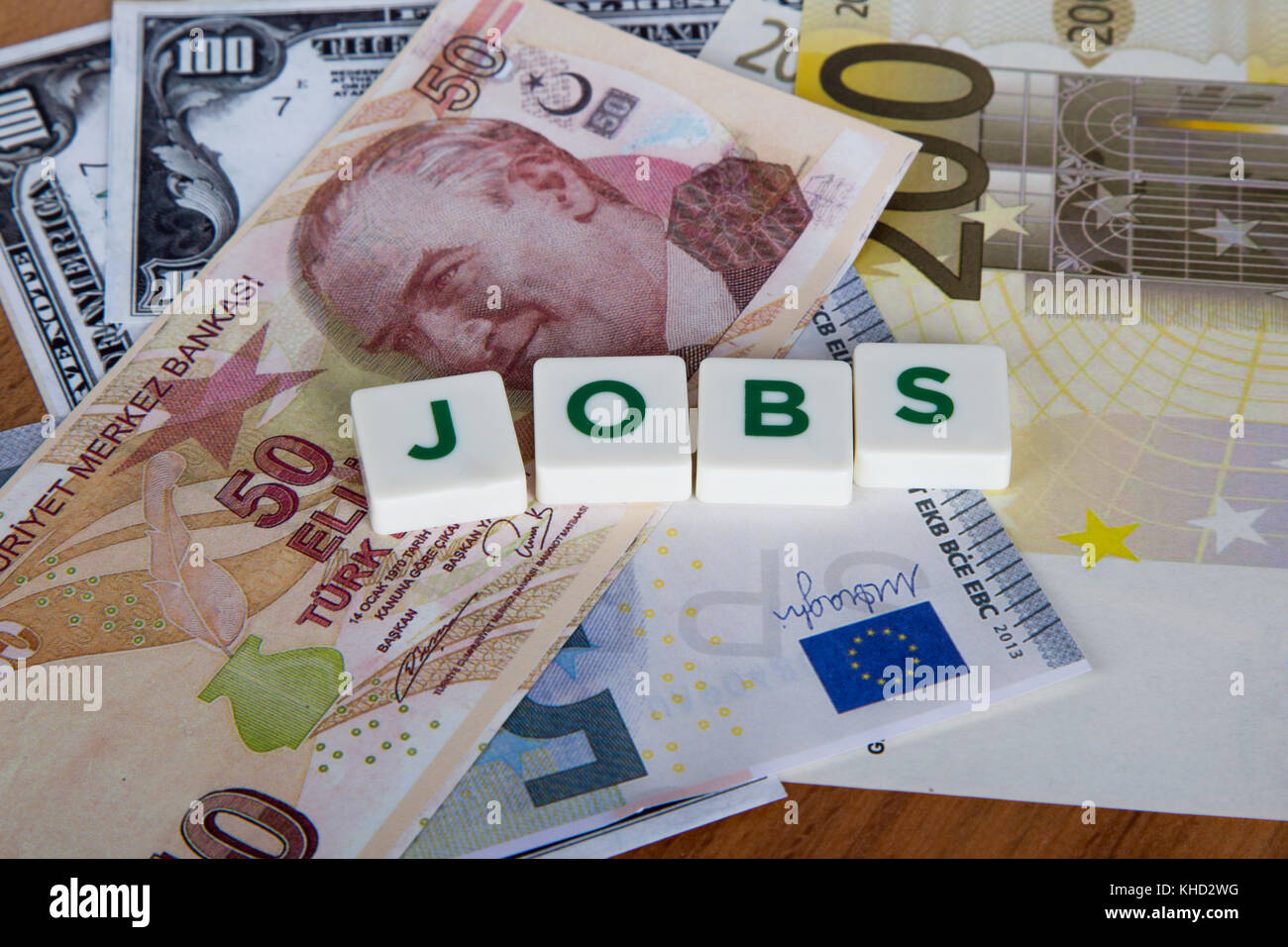 Jobs word with green letters among cash dollar, euro and turkish lira  banknotes on wooden background Stock Photo - Alamy