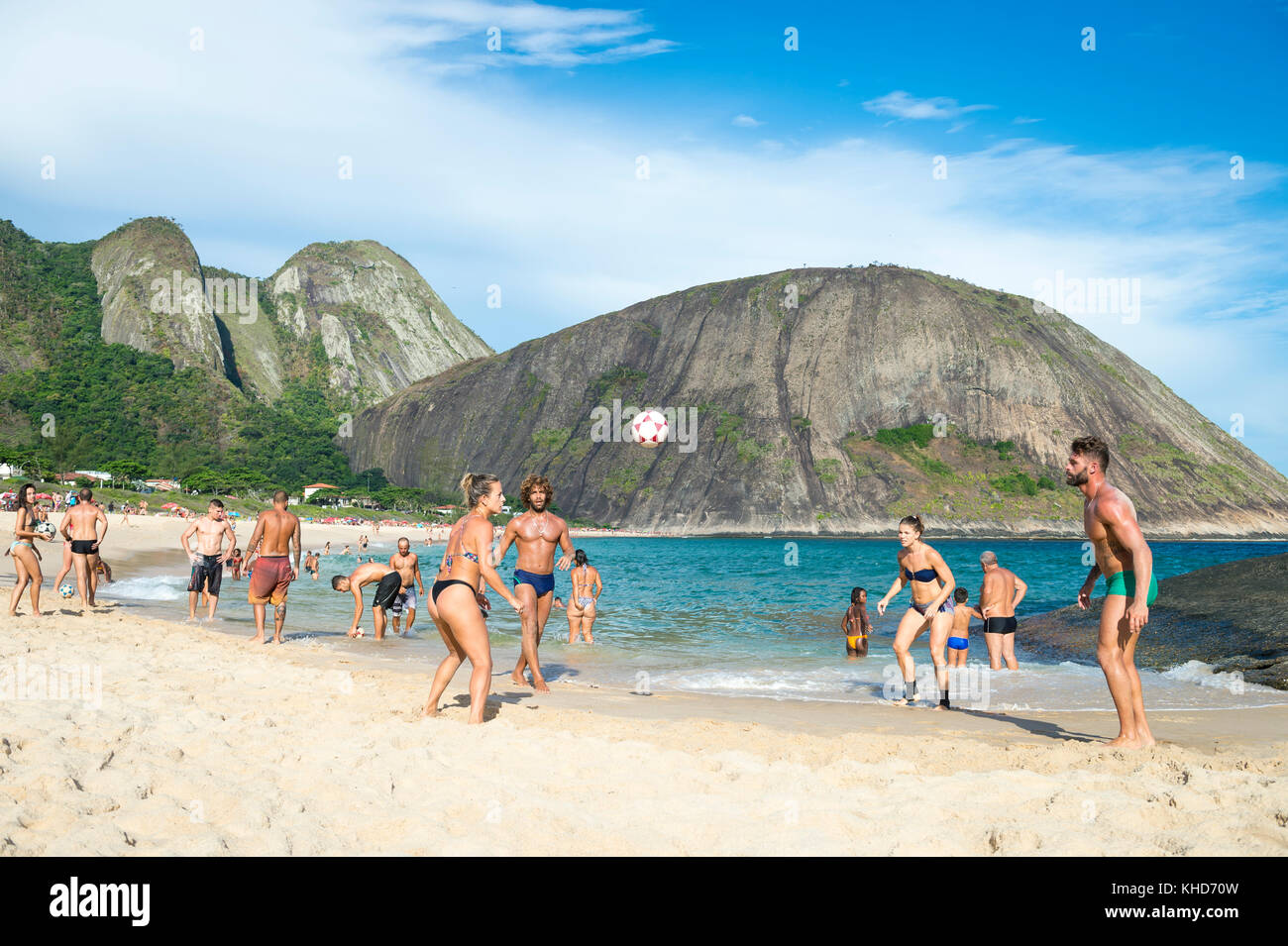 RIO DE JANEIRO - MARCH 4, 2017: Young Brazilians play a game of keepy-uppies (known locally as altinho) on the shore of Itacoatiara Beach. Stock Photo
