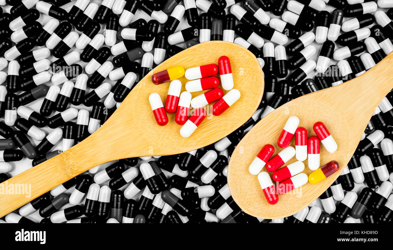 Colorful Of Antibiotics Capsule Pills In Wooden Spoon On Black And