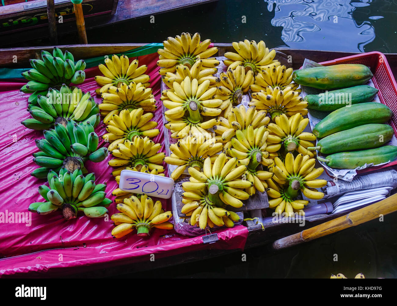 Selling banana and papaya on boats at Damnoen Saduak floating market in Bangkok, Thailand. This