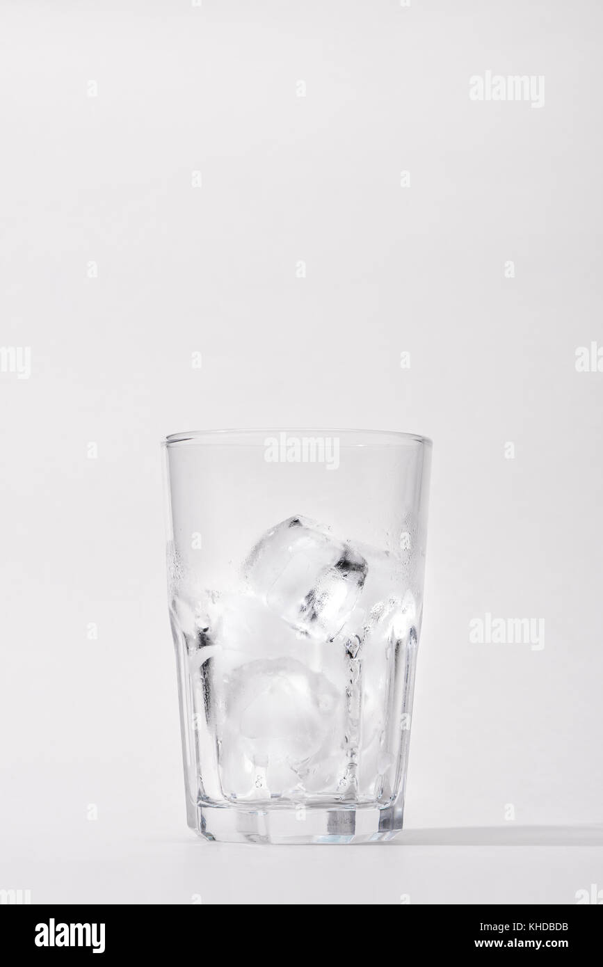 Glass with ice cubes on white background Stock Photo - Alamy