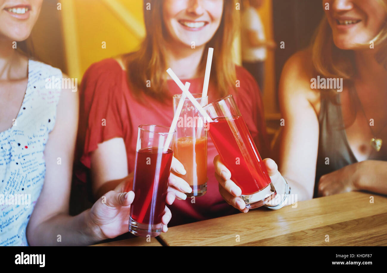 healthy drinks, group of people smiling and cheering together in cafe with glasses of smoothies Stock Photo
