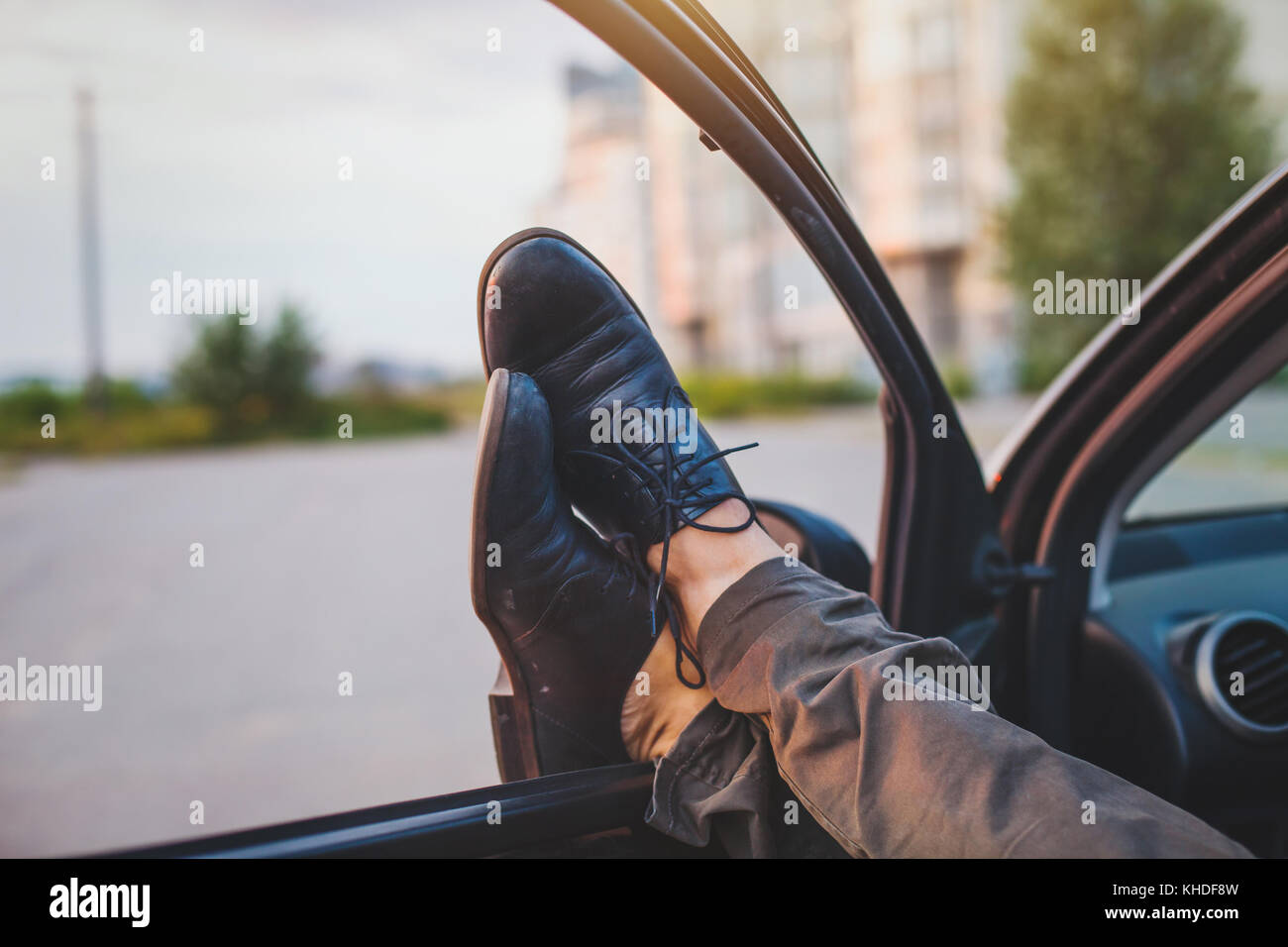 man sleeping in his car, tired driver stretching legs Stock Photo