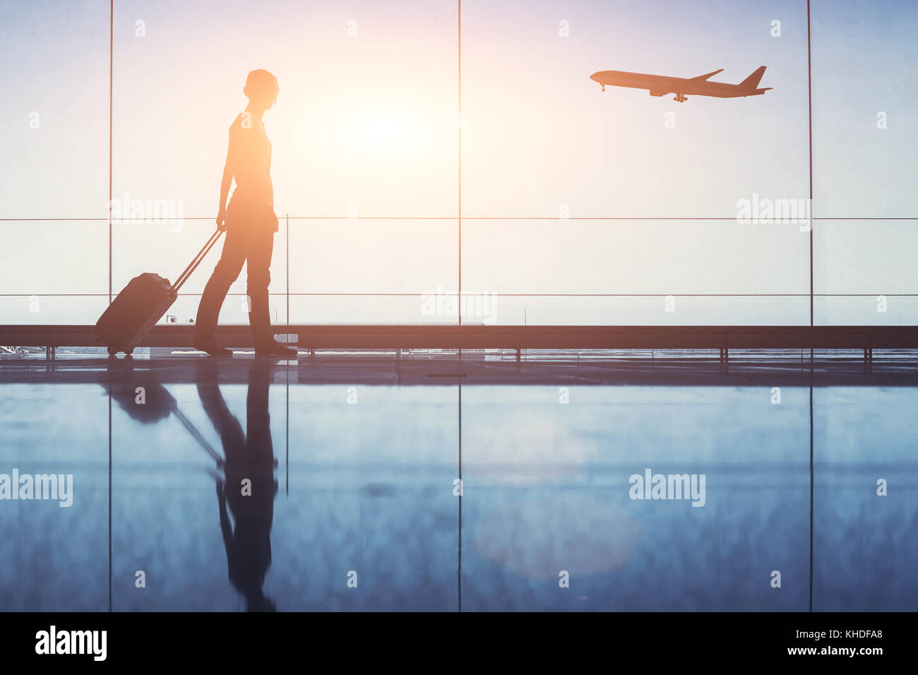 people traveling, silhouette of woman passenger with baggage in airport Stock Photo