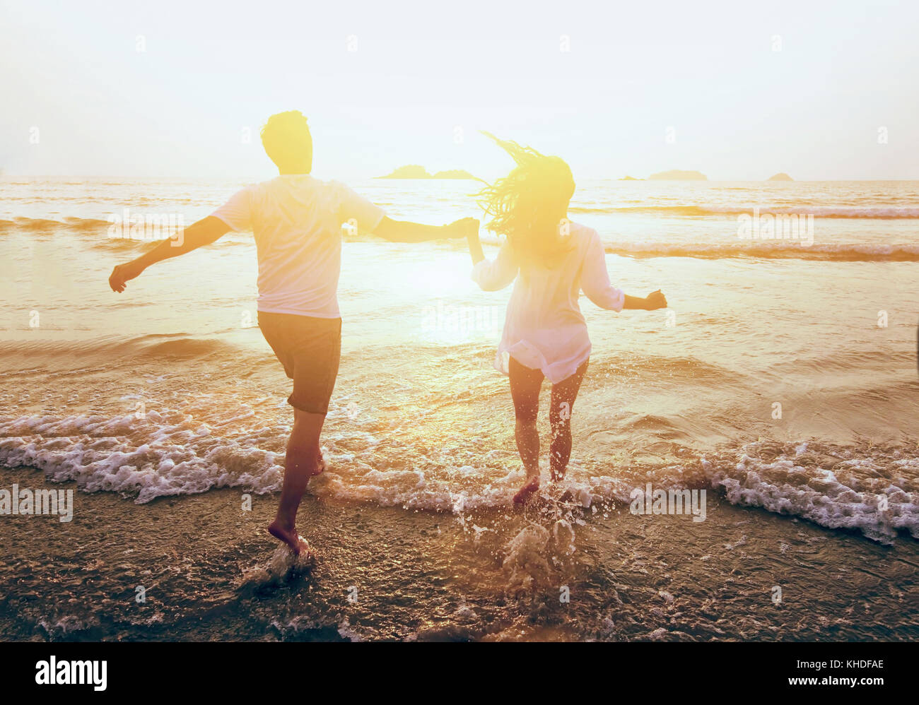 young happy couple running to the sea on the beach, summer holidays travel Stock Photo