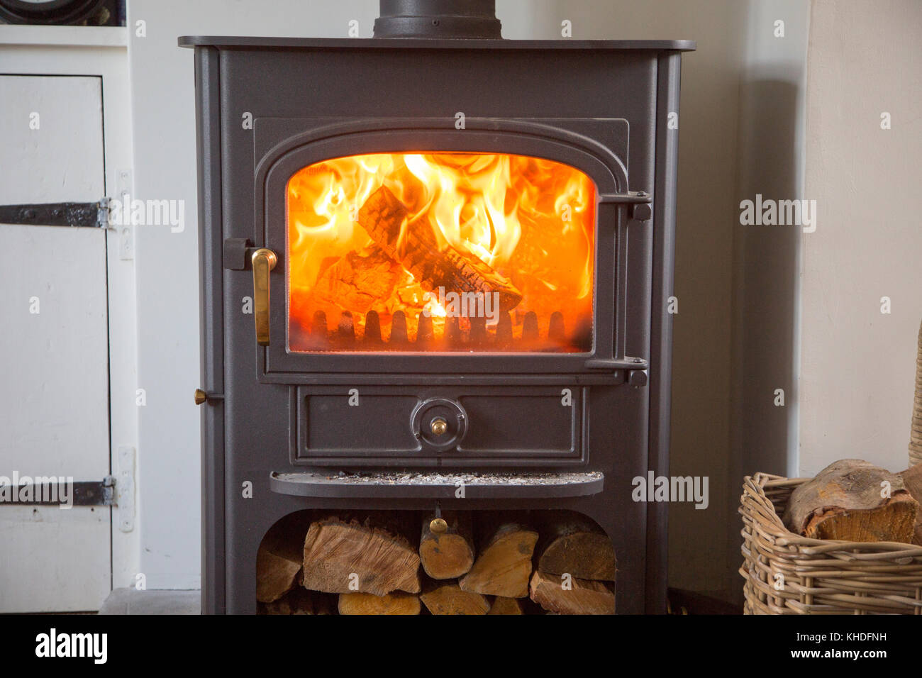 Warm fire flames logs burning in ClearView domestic multifuel stove burner inside home, UK Stock Photo